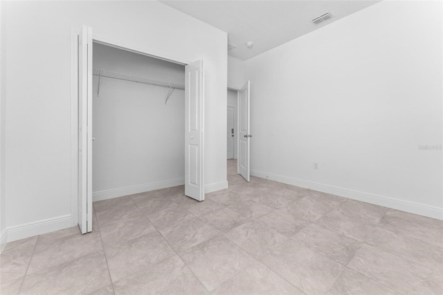 unfurnished bedroom with a closet and light tile floors