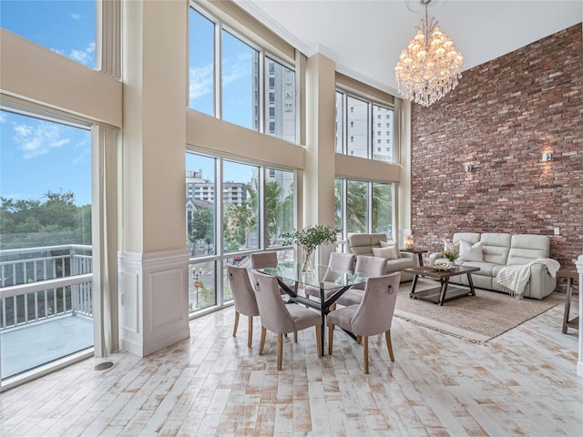 unfurnished dining area featuring a high ceiling, an inviting chandelier, and plenty of natural light