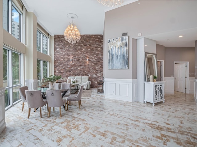 dining space featuring a towering ceiling and a notable chandelier