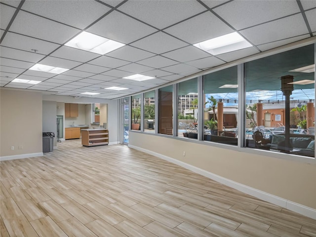 interior space featuring a drop ceiling and light wood-type flooring