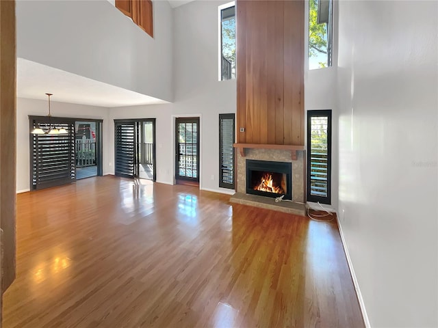 unfurnished living room featuring a towering ceiling and hardwood / wood-style flooring