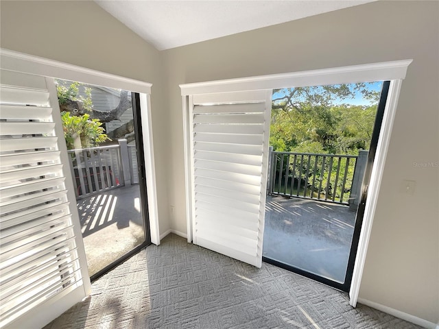 entryway with vaulted ceiling and carpet