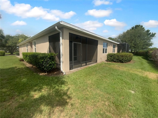 33083 Windelstraw Dr, Wesley Chapel, FL 33545 - rear view of property featuring stucco siding, a yard, and a sunroom
