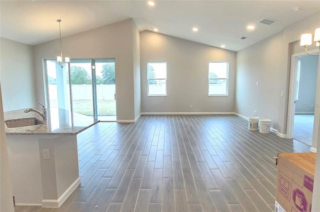 interior space with dark hardwood / wood-style flooring, sink, a notable chandelier, and vaulted ceiling