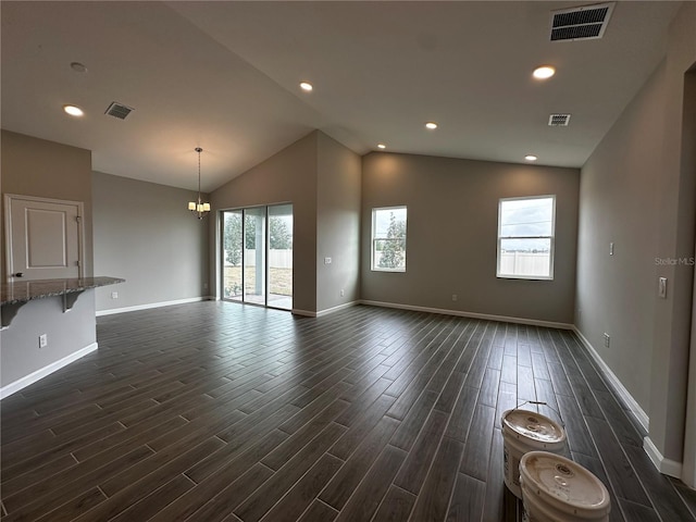 unfurnished living room featuring lofted ceiling and an inviting chandelier