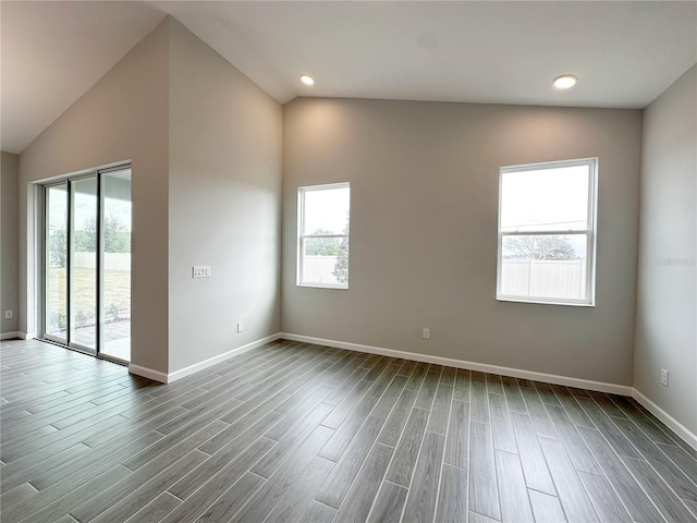 empty room featuring vaulted ceiling and dark hardwood / wood-style floors