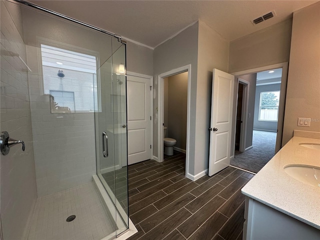 bathroom featuring walk in shower, vanity, and toilet