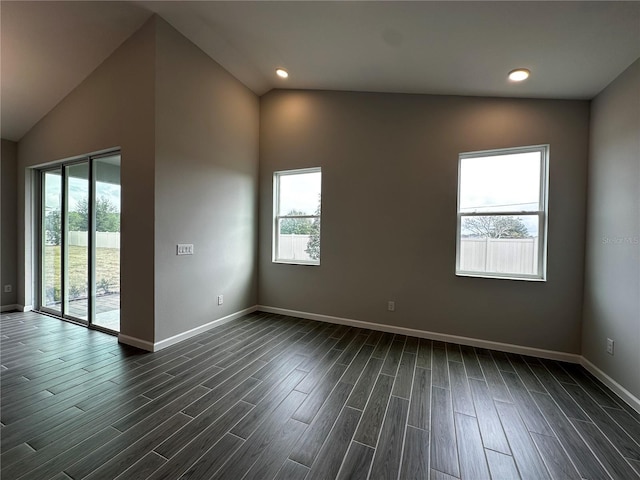 spare room with vaulted ceiling and dark hardwood / wood-style flooring