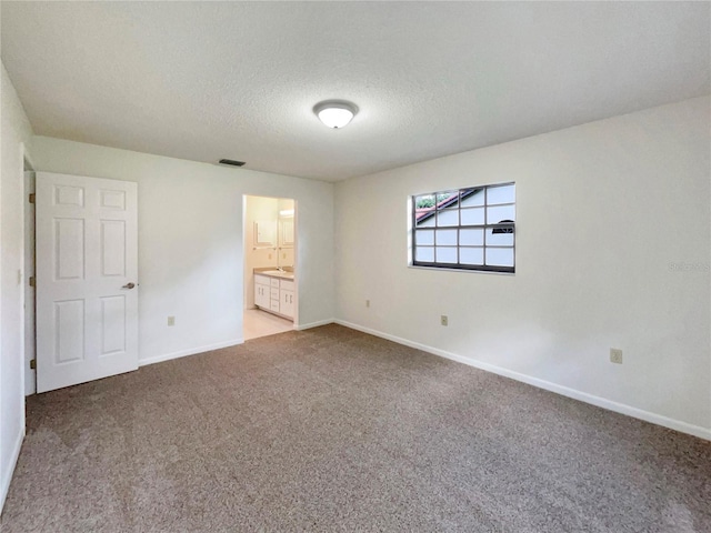 carpeted empty room featuring a textured ceiling