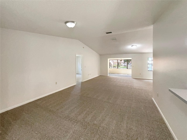 unfurnished living room with vaulted ceiling and carpet