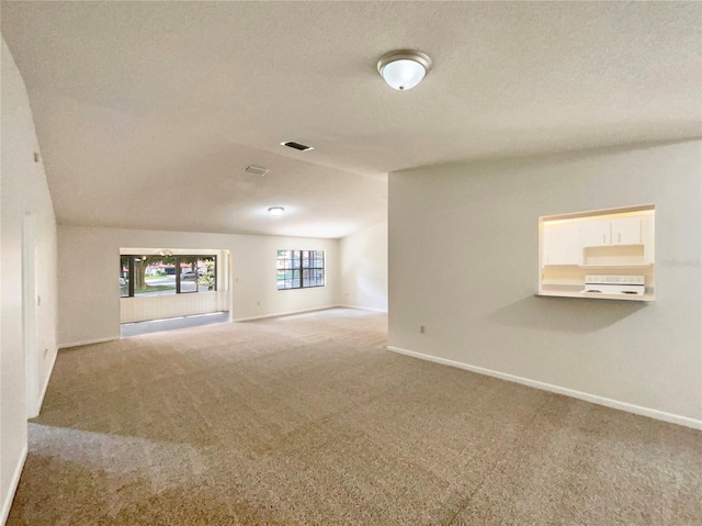 unfurnished living room with a textured ceiling and carpet flooring