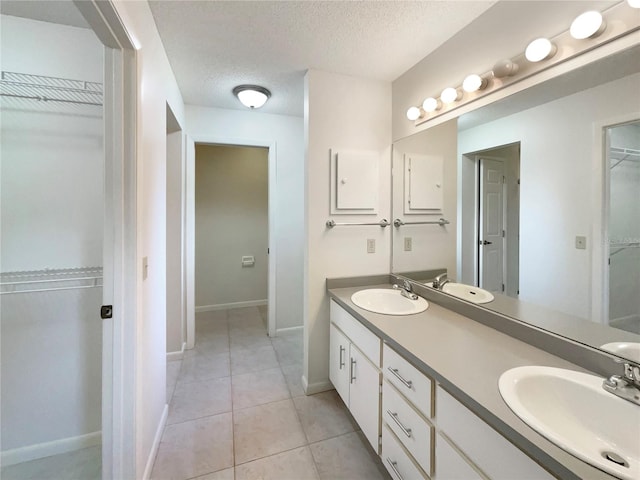 bathroom with vanity, a textured ceiling, and tile patterned floors