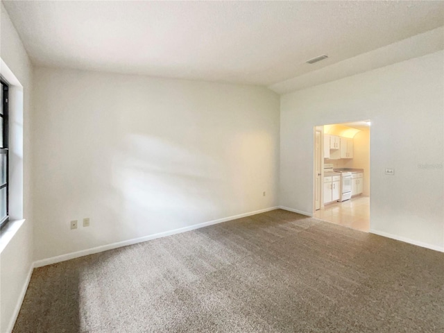 carpeted spare room with lofted ceiling