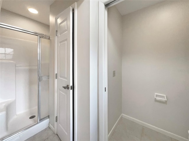 bathroom featuring a shower with shower door and tile patterned flooring