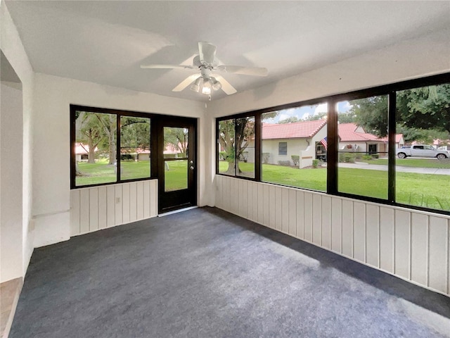 unfurnished sunroom with ceiling fan