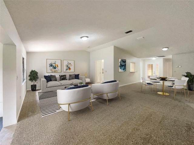 living room featuring light carpet, lofted ceiling, and a textured ceiling