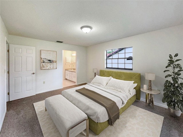 bedroom featuring a textured ceiling, connected bathroom, and carpet floors