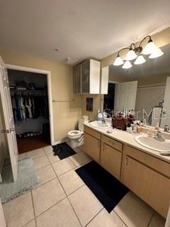 bathroom featuring vanity with extensive cabinet space, double sink, and tile flooring