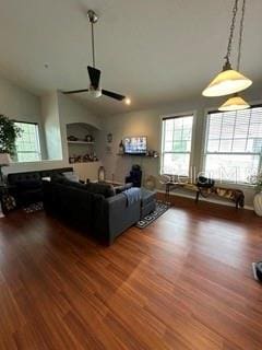 living room with dark wood-type flooring and ceiling fan