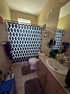 bathroom with large vanity, toilet, and tile flooring