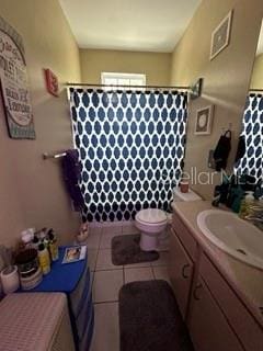 bathroom featuring toilet, tile flooring, and vanity