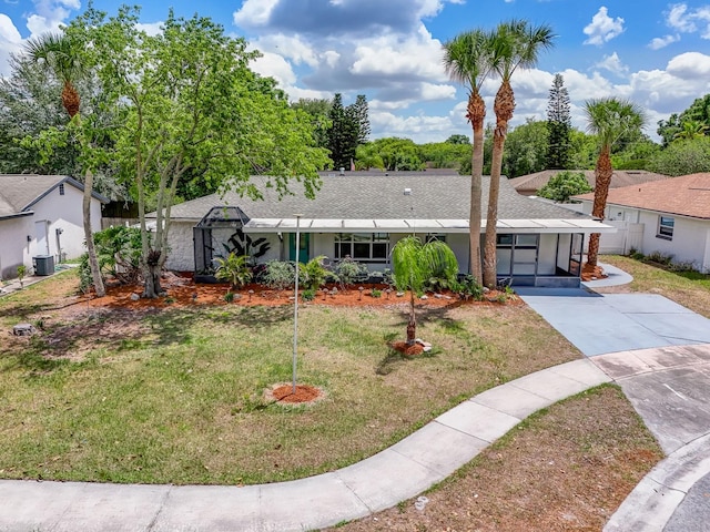 ranch-style house with central air condition unit and a front yard