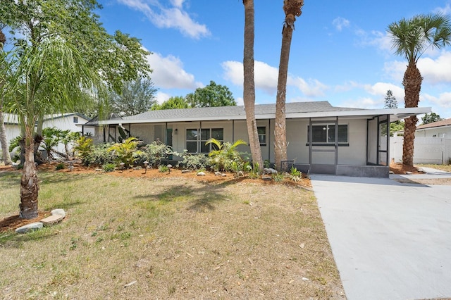 single story home featuring a front lawn and a sunroom