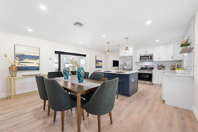 dining room featuring sink and light hardwood / wood-style flooring