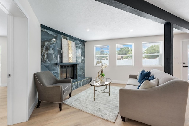 living room featuring a textured ceiling, wood-type flooring, and a fireplace