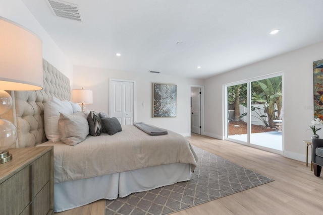 bedroom with access to exterior, light wood-type flooring, and a closet