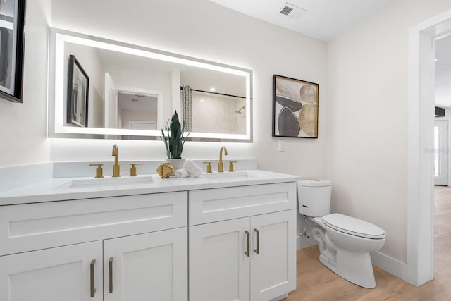 bathroom with vanity, hardwood / wood-style flooring, and toilet