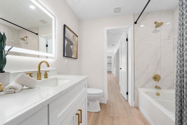 full bathroom featuring hardwood / wood-style floors, shower / bath combo, toilet, and vanity