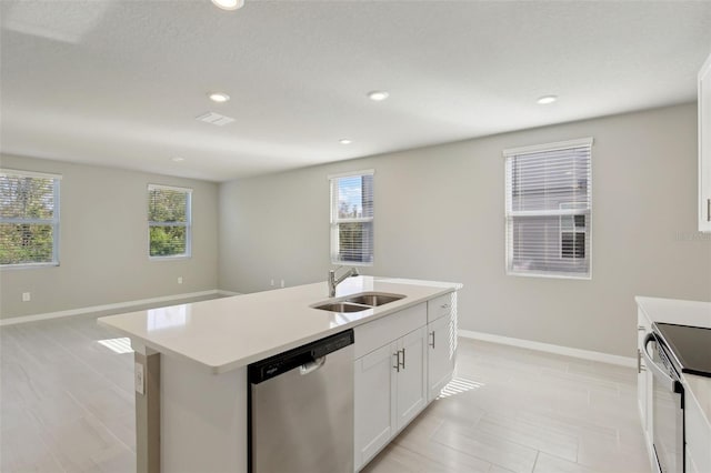 kitchen with sink, stainless steel dishwasher, range with electric stovetop, an island with sink, and white cabinetry