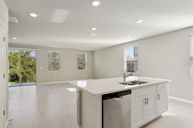 kitchen with stainless steel dishwasher, a center island with sink, white cabinetry, and sink