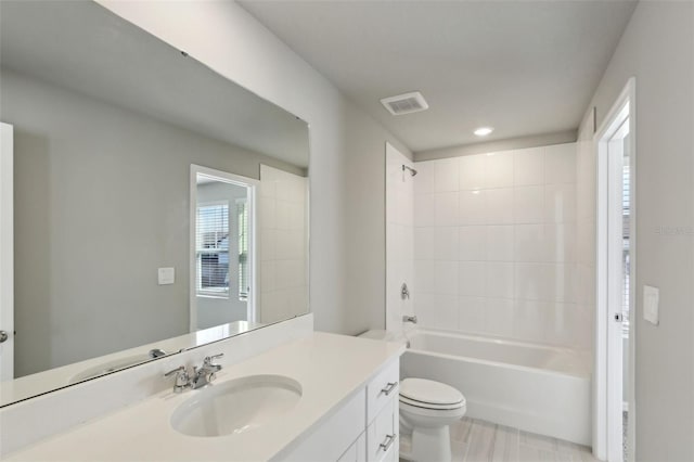 full bathroom featuring tiled shower / bath combo, toilet, and vanity