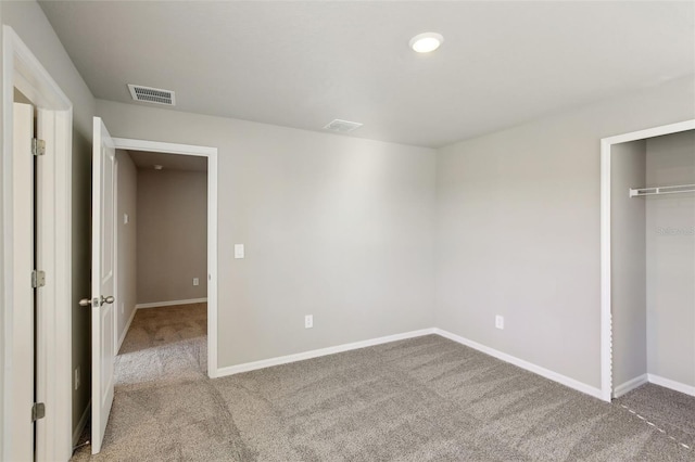 unfurnished bedroom featuring light colored carpet and a closet