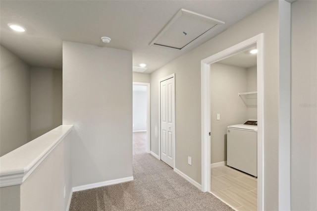 hall featuring washer / dryer and light colored carpet