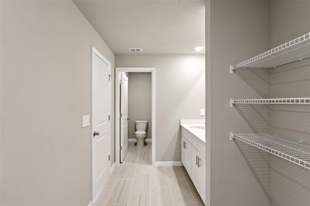 bathroom with tile patterned flooring, vanity, and toilet