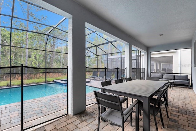 view of swimming pool featuring outdoor lounge area, glass enclosure, a patio area, and an in ground hot tub