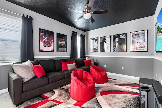 tiled cinema with ceiling fan and a textured ceiling