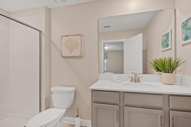 bathroom featuring vanity, an enclosed shower, and toilet