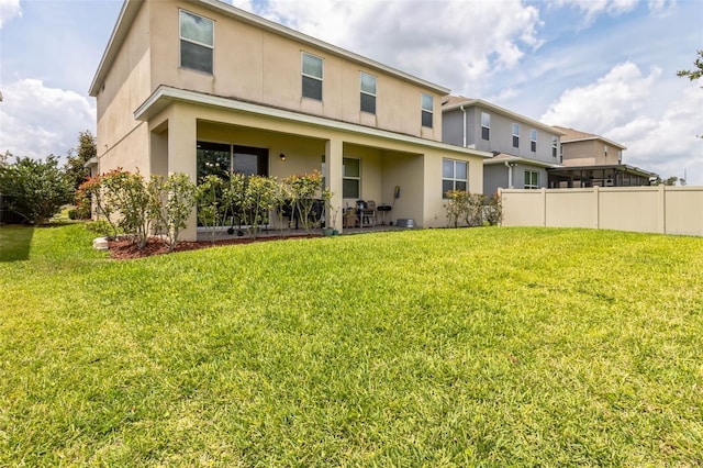 rear view of property with a yard