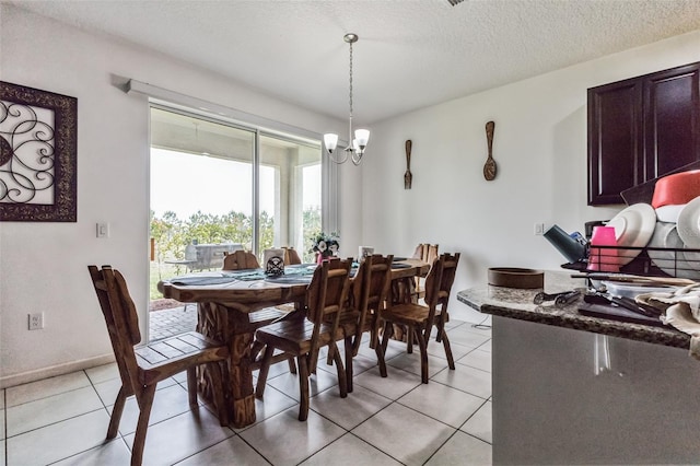 tiled dining space featuring a notable chandelier and a textured ceiling