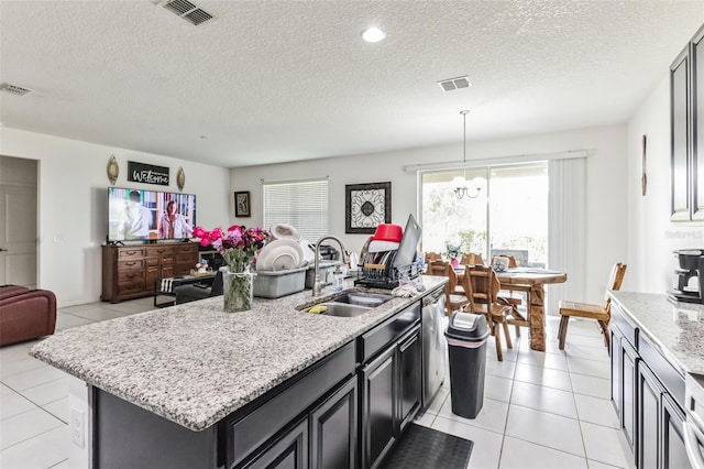 kitchen featuring a center island, sink, light tile flooring, and pendant lighting