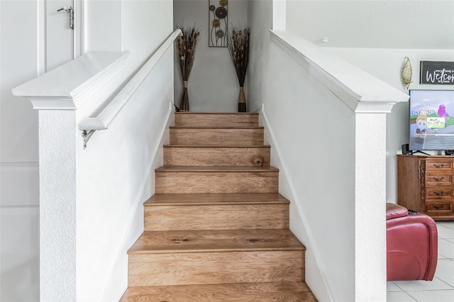 stairway featuring light tile flooring