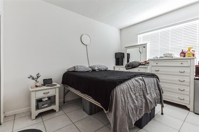 bedroom featuring a textured ceiling and light tile floors