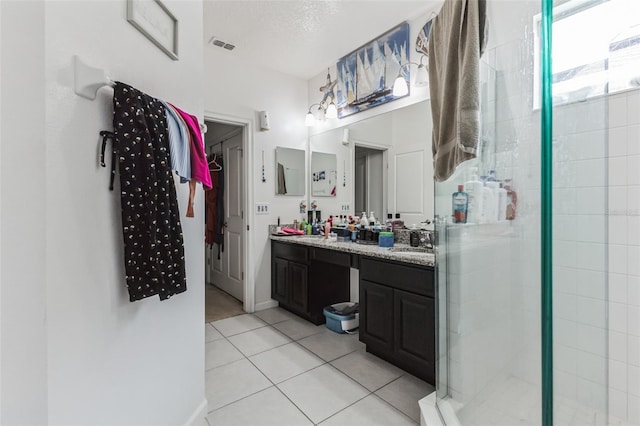 bathroom with tile flooring, an enclosed shower, and vanity