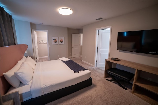 carpeted bedroom with a spacious closet and a closet