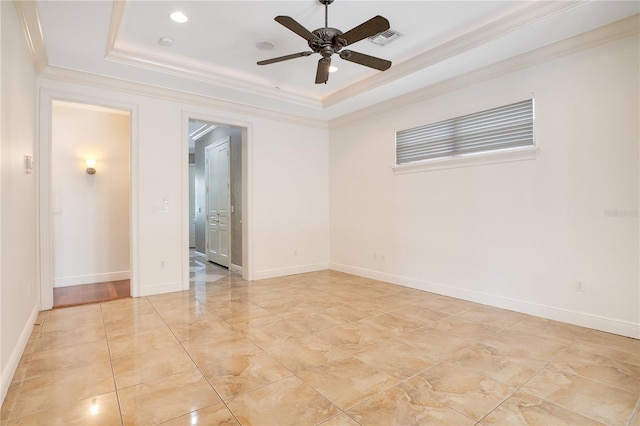 unfurnished room featuring a raised ceiling, ceiling fan, light tile floors, and ornamental molding