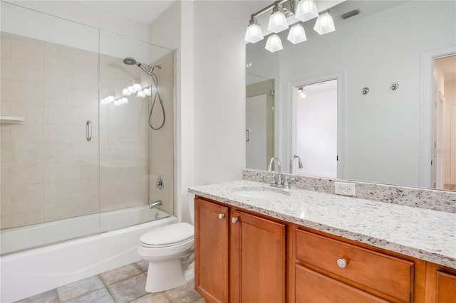 full bathroom with toilet, tile floors, vanity with extensive cabinet space, and bath / shower combo with glass door